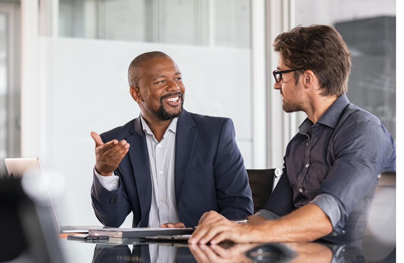 2 colleagues in conversation across a meeting table