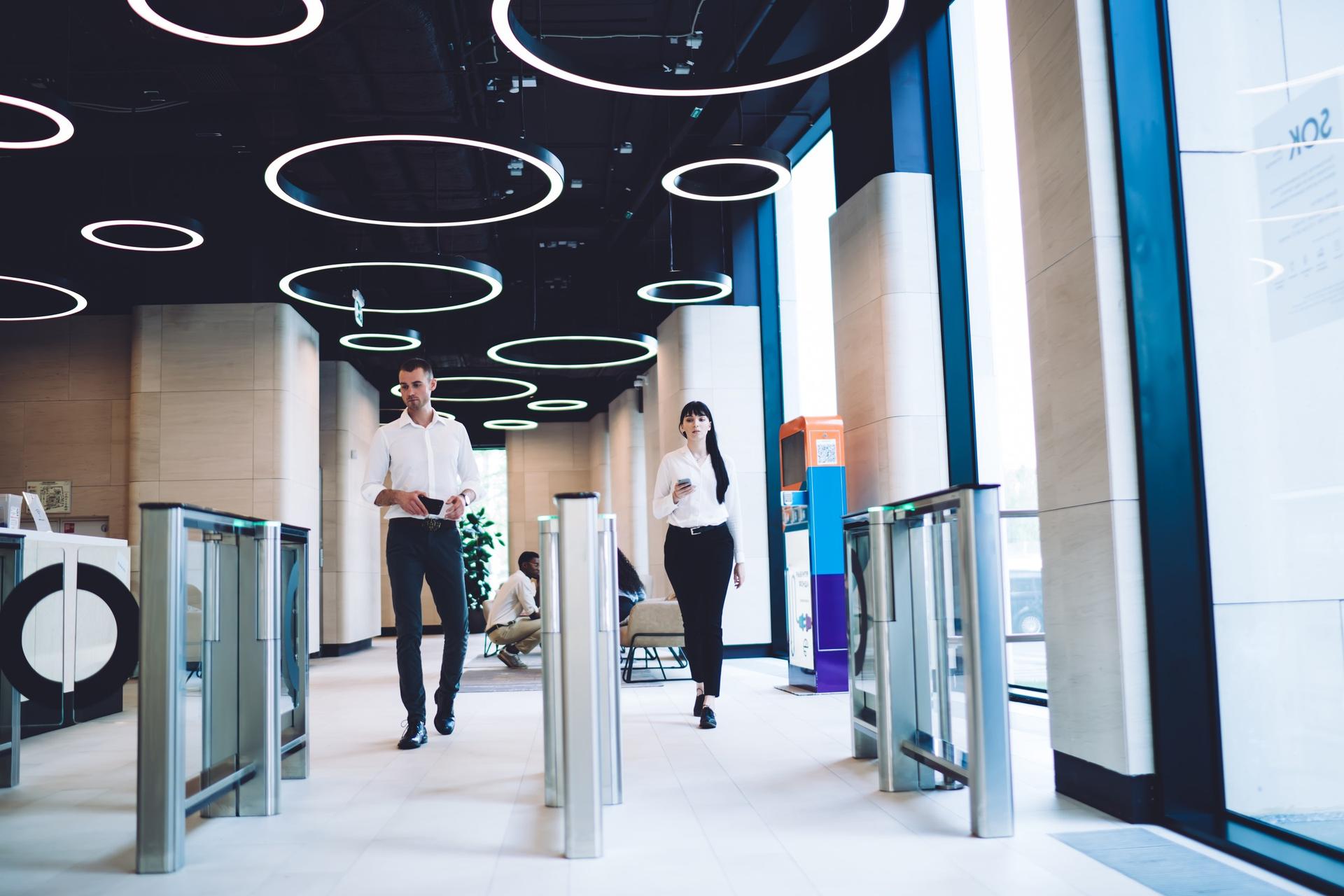 People walking through speed gates in an office lobby