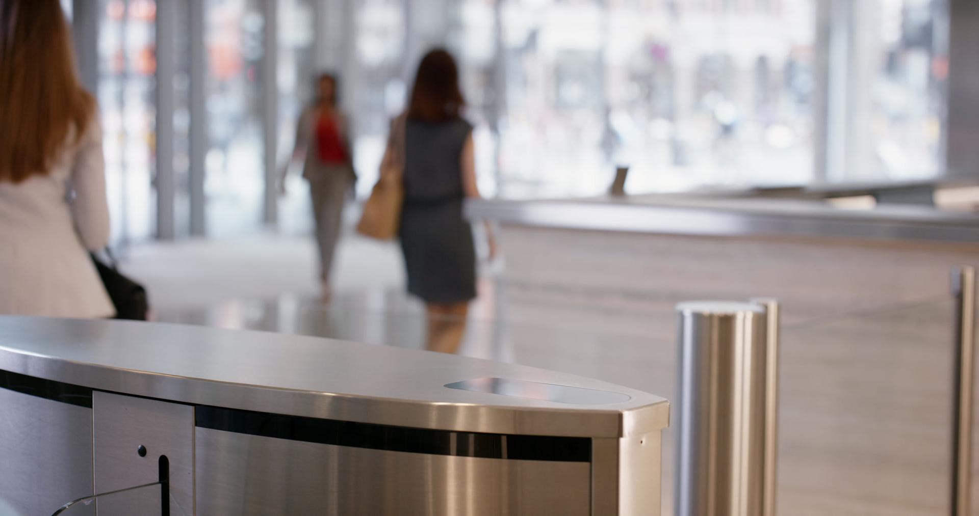 Colleagues walking on past the entrance gates of an office lobby